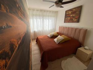 a bedroom with a bed and a painting on the wall at Le Cosy Corse in Vico