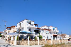 a white building with an umbrella in front of it at Estella Studios in Elafonisos