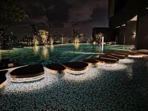 a swimming pool at night with a city in the background at 1-12PAXKuala Lumpur Near Taman MIDAH Cheras 2 Car Parking normally 1 parking only in Kuala Lumpur