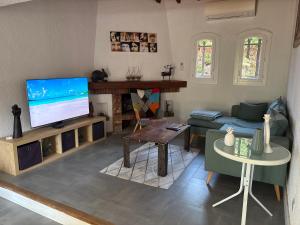 un salon avec une télévision et un canapé dans l'établissement Magnifique villa avec piscine, à Boulouris-sur-Mer