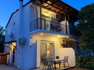 a house with a table and chairs in front of it at Prime Diakopto in Diakopto