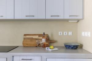 a kitchen counter with a bottle of wine and a bowl at Iremia Coastal Retreat - Private Sea View Terrace in Neo Klima