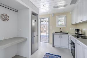 a kitchen with white cabinets and a counter top at Iremia Coastal Retreat - Private Sea View Terrace in Neo Klima
