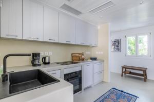 a kitchen with white cabinets and a sink at Iremia Coastal Retreat - Private Sea View Terrace in Neo Klima