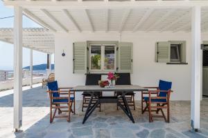 a dining table and chairs on a patio at Iremia Coastal Retreat in Neo Klima