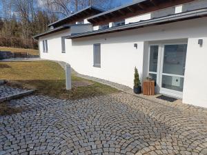 a house with a brick driveway in front of it at Haus im Grünen - Aktiv-Card Partner! in Regen