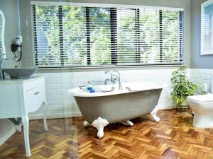 a bathroom with a large tub and a toilet at C'est La Vie Boutique Hotel in Witbank +17 photos
