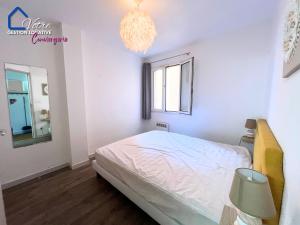 a bedroom with a bed and a window and a chandelier at L'Empereur Colliourenc in Collioure
