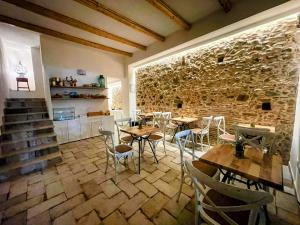 a restaurant with tables and chairs and a stone wall at Scirocco Affittacamere in Oliveri