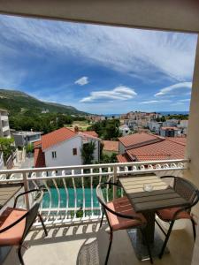 a balcony with a table and chairs and a pool at Pension Alba in Podstrana