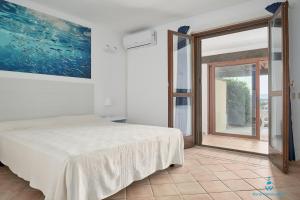 Postel nebo postele na pokoji v ubytování Due bilocali ristrutturati nel 2025 con vista panoramica su Porto Ottiolu