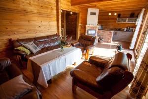 a living room with leather couches and a table at Litewska Chata in Poćkuny