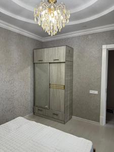 a bedroom with a bed and a chandelier at Yunusabad Comfort House in Yunusobod