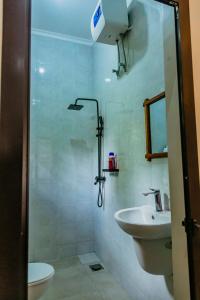 a bathroom with a sink and a toilet and a shower at Dodo homes in Uru