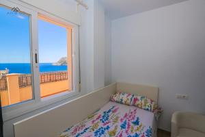 Un dormitorio con una ventana con vista al mar. en Penthouse Ocean Views and Garage, en La Herradura