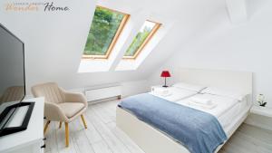 biała sypialnia z łóżkiem i krzesłem w obiekcie Wonder Home - Apartament blisko Ski Arena, szlaków turystycznych i Kościółka Wang w mieście Karpacz