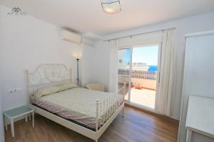 Un dormitorio con una cama y una ventana grande en Penthouse Ocean Views and Garage, en La Herradura
