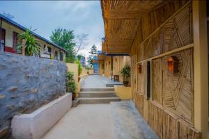 an empty alleyway between two buildings with a stone wall at Babylon Bamboo Cottage in Pokhara