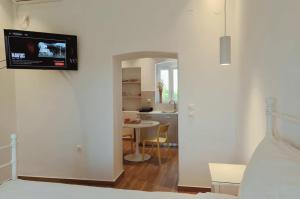 a room with a bed and a television on a wall at Haroto Suites in Tripiti