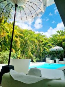 a view of a swimming pool with an umbrella at Sandy Bay Villa Opale in Le Moule