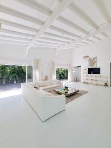 a white living room with a couch and a table at Sandy Bay Villa Opale in Le Moule