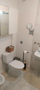a white bathroom with a toilet and a sink at Apartamento Danubio in El Puerto de Santa María