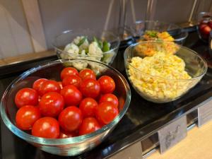 a counter with bowls of tomatoes and other ingredients at Onyado Nono Matsumoto Natural Hot Spring in Matsumoto