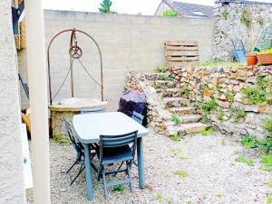 a table and chairs in a backyard with a stone wall at La maisonnette cachée de Dampmart in Dampmart +3 photos