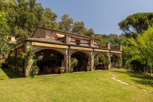 a large house with a porch in the grass at Finca La Lobera in Candeleda