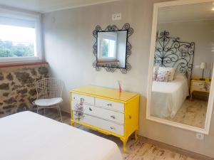 a bedroom with a yellow dresser and a mirror at Bungalow MAR Y MONTAÑA in Laredo