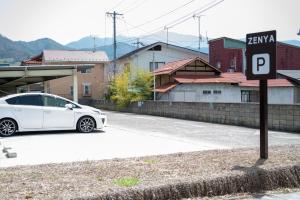 Ein weißes Auto parkte neben einem Parkschild. in der Unterkunft Zenya-Nakano in Nakano + 20 Fotos