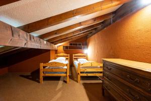 a bedroom with two bunk beds and a dresser at Appartement 12 - Les Aravis in Crest-Voland