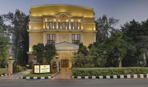 un grande edificio giallo con un cartello di fronte di Mayfair Convention a Bhubaneshwar