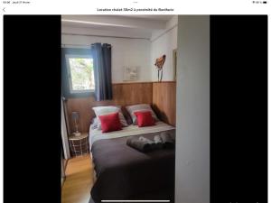 a bedroom with a large bed with red pillows at chalet Bati in Bonifacio
