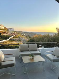 eine Terrasse mit Sofas und Meerblick in der Unterkunft First line with ocean views in Cala en Forcat