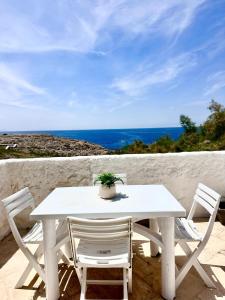 einem weißen Tisch mit zwei Stühlen und einer Topfpflanze in der Unterkunft First line with ocean views in Cala en Forcat