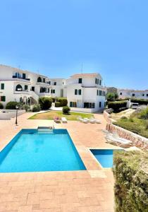 ein großes Schwimmbad vor einem Haus in der Unterkunft First line with ocean views in Cala en Forcat