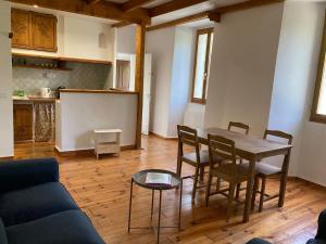 un salon avec une table et des chaises et une cuisine dans l'établissement Confortable logement au coeur des montagnes, au Lauzet-Ubaye 4 autres photos