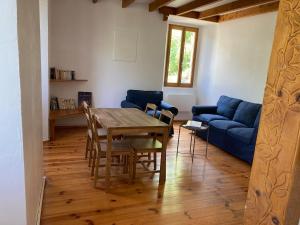 un salon avec une table et un canapé bleu dans l'établissement Confortable logement au coeur des montagnes, au Lauzet-Ubaye