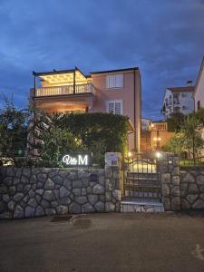 a large house with a stone wall in front of it at Villa M in Crikvenica
