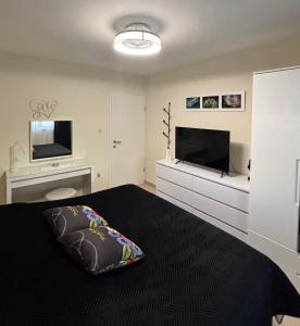 ein Schlafzimmer mit einem Bett und einem Flachbildfernseher in der Unterkunft Apartmani Merica in Pakoštane