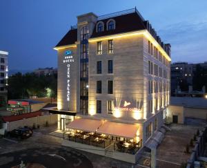 a lit up building with a sign on it at Ozen Palace Hotel in Almaty