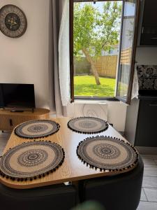 two plates on a wooden table with a window at Chez Sylviane Rez-de-Chaussée 200 m de la mer in Luc-sur-Mer