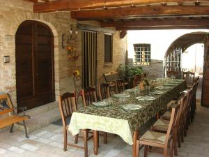 una mesa larga en un patio con sillas y mesa en Agriturismo Il Borghetto, en Montefalco