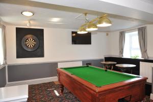 a room with a pool table and a clock on the wall at California Hotel in Brynteg