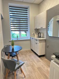 a kitchen with a table and chairs and a window at KunK in Ventspils