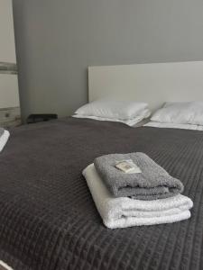 a bed with a pile of towels on it at KunK in Ventspils