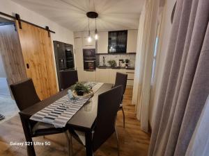 a dining room table with chairs and a kitchen at Indigo Dreams in Ogulin