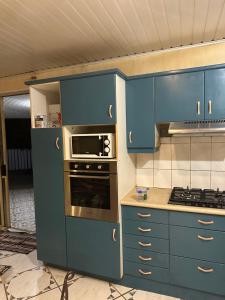 a kitchen with blue cabinets and an oven at Les Tainas bis in Faaa