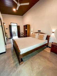 una camera da letto con un letto grande in una stanza di Coconut Beach House a Galle
